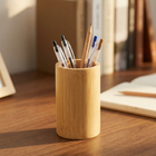 Bamboo Pen Stand PS-2 holding pens and a pencil on a walnut desk