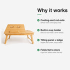 Bamboo laptop bed table features — cooling-vent cut-outs, built-in cup holder, tilting panel with ledge, folds flat.