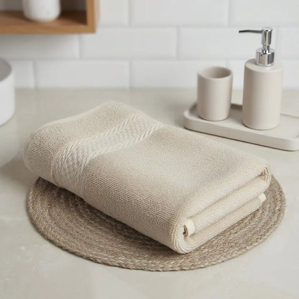 Bamboo Bath Towels folded on a round placemat in a modern bathroom setting.