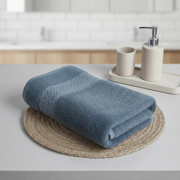 Bamboo Bath Towels folded neatly on a table with a soap dispenser and ceramic cups in a stylish bathroom setting.