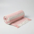 Bamboo Bath Towel rolled in soft pink with cream stripes and fringes for a stylish bathroom accent.