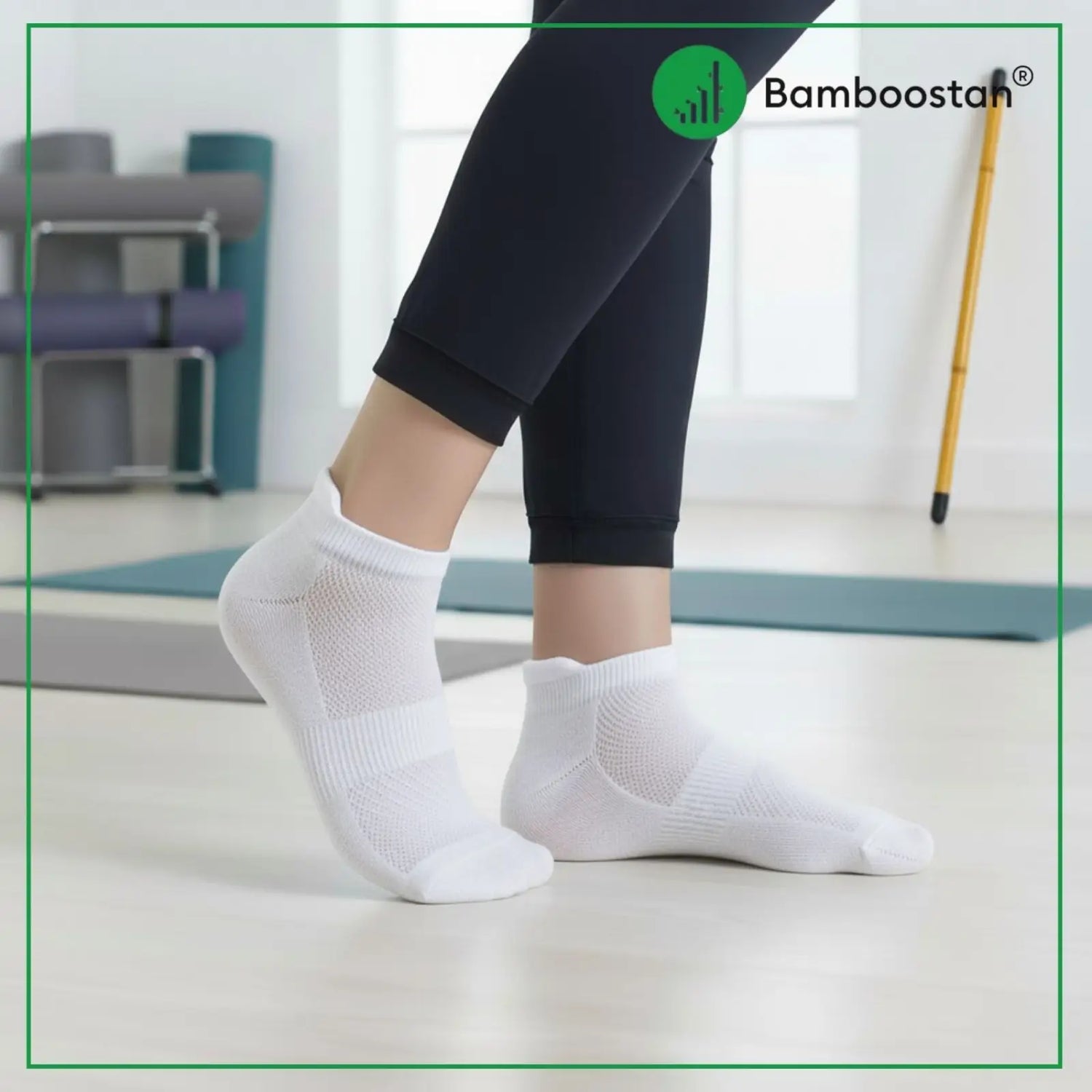 Person wearing white bamboo socks with a blurred indoor background, featuring the Bamboostan brand logo.