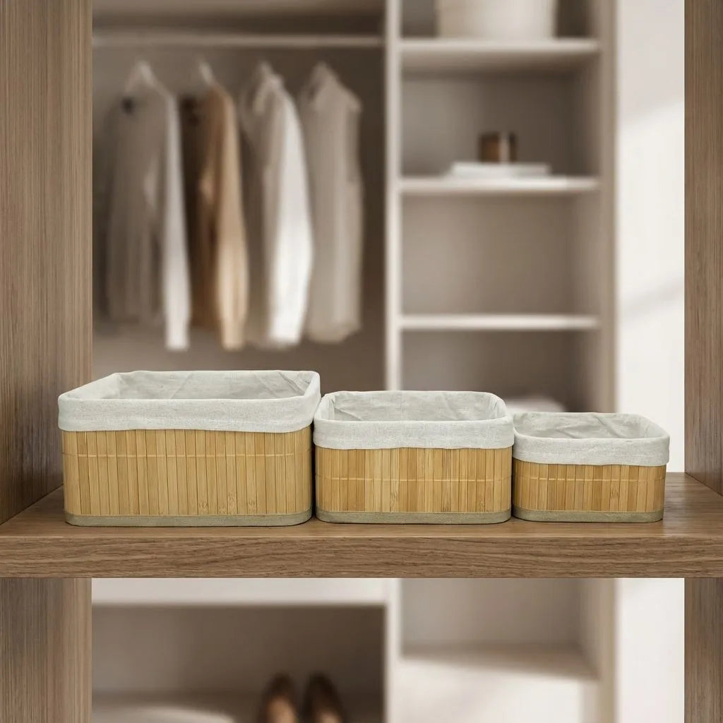 Set of three bamboo storage baskets with off white liners on a wooden shelf.