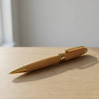 Bamboo pen with gold accents on a wooden surface