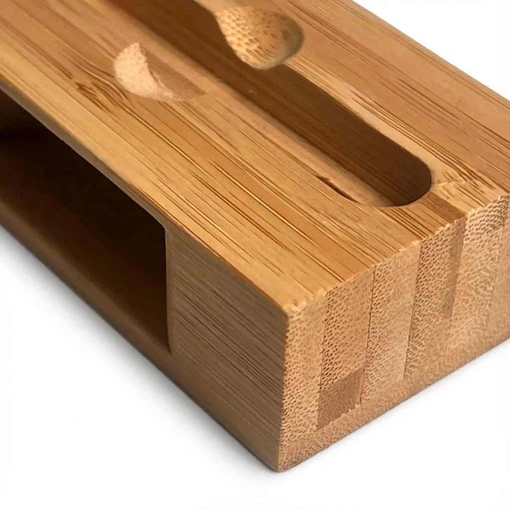Close-up of a bamboo block with rectangular holes on a white background