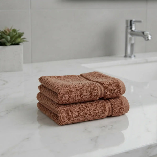 Stack of brown color bamboo hand towels on a marble countertop with a blurred bathroom background