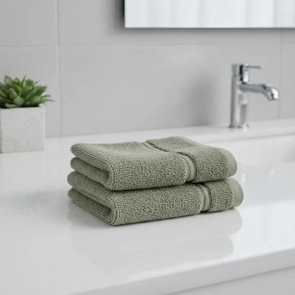 Stack of Bamboo Green hand towels on a white countertop with a blurred background