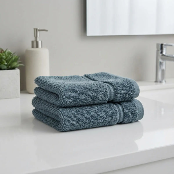 Stack of blue bamboo hand towels on a white countertop with a neutral background