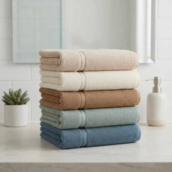 Stack of folded bamboo hand towels in various colors on a bathroom counter.