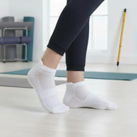 Person wearing Bamboo Ankle Socks while exercising on a yoga mat in a bright home setting.