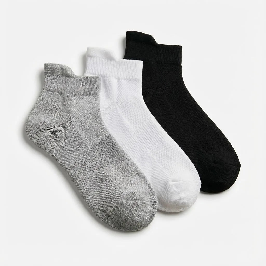Three pairs of bamboo socks in gray, white, and black on a light gray background