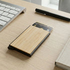 Bamboo pocket card holder on a desk with keyboard and pen, showcasing sleek design and natural finish.