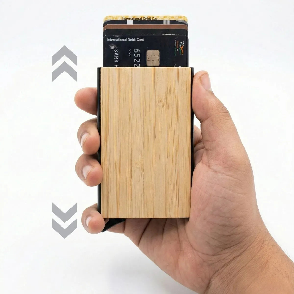 Bamboo pocket card holder in hand showcasing its sleek design with cards partially ejected for easy access.
