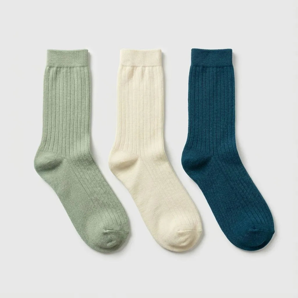Three pairs of bamboo socks in green, white, and blue on a light gray background
