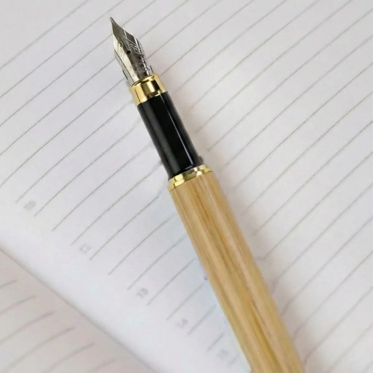 Close-up of a Premium Bamboo Pen resting on lined paper, showcasing its elegant design and smooth writing tip.