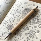 Bamboo Mechanical Pencil resting on a doodle-filled sketchbook, ideal for smooth writing and drawing.