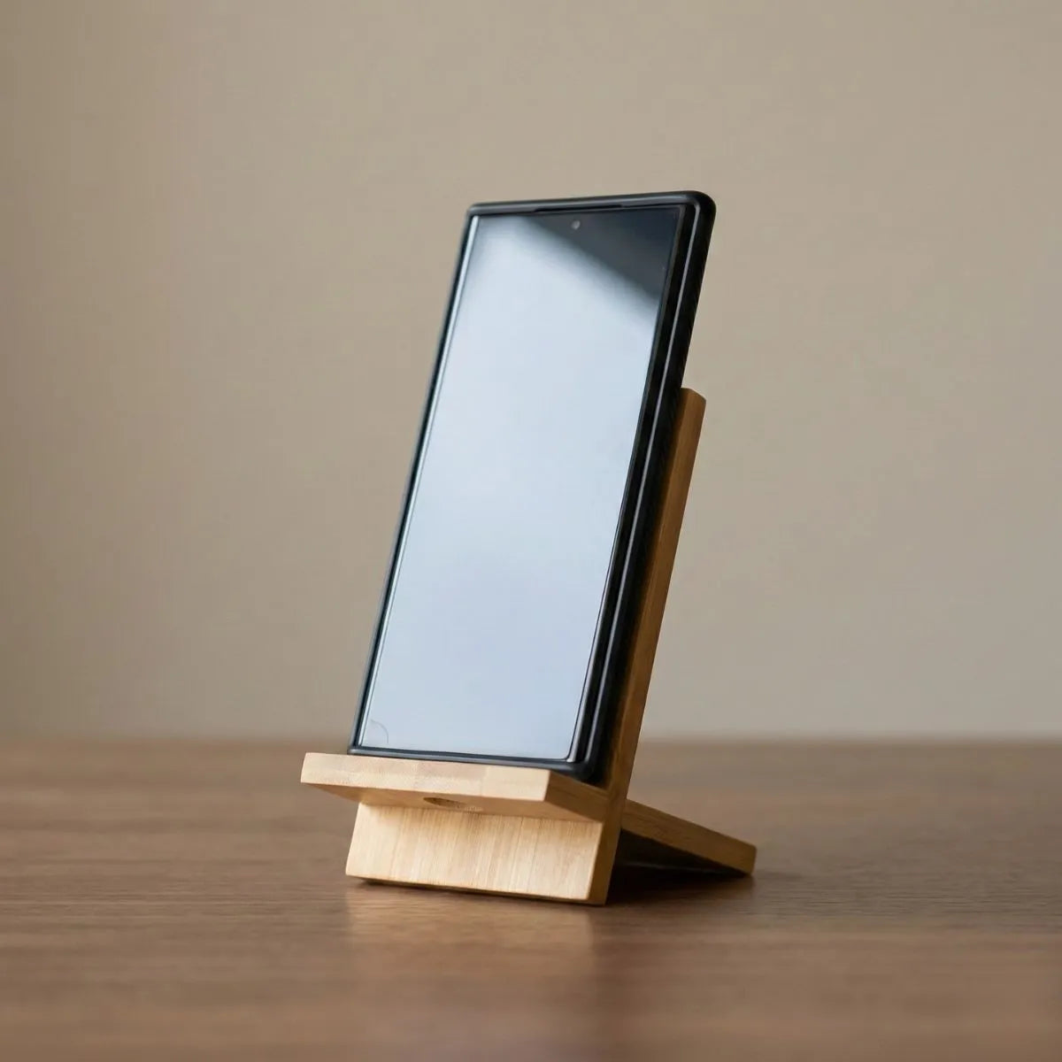 Bamboo Phone Stand holding a smartphone at a comfortable viewing angle on a wooden desk.