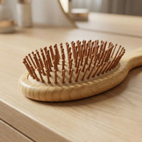 Bamboo Oval Hairbrush designed for smooth detangling and soothing scalp massage on a wooden vanity.