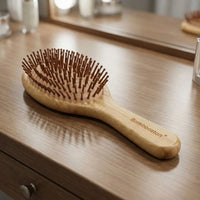 Bamboo Oval Hairbrush on a wooden table with a gentle design for smooth detangling and soothing scalp massage.
