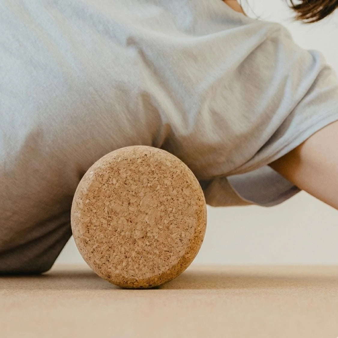 Person using a cork roller on a light-colored surface