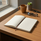 Cork Notebook (160 pages) opened on a wooden desk with a coffee cup and glasses nearby, ideal for journaling and planning.