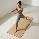 Woman practicing yoga on a Cork Yoga Mat, showcasing stability and comfort during stretches.