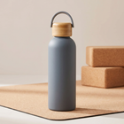 Water Bottle 500ml in matte grey on a cork yoga mat, bamboo cap with carry handle.