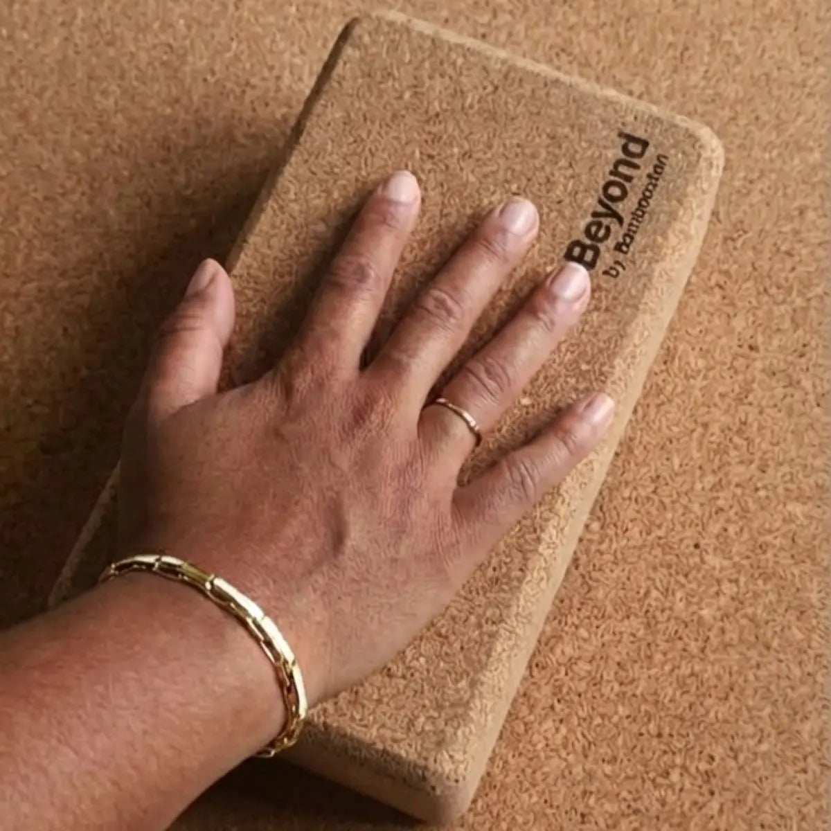 Hand resting on a cork yoga block.